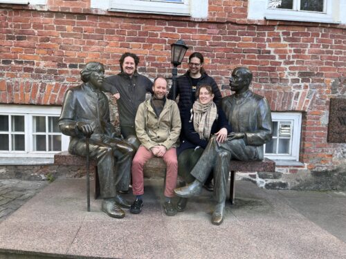 En gruppbild på deltagarna vid den kända Wilde-statyn i Tartu, som porträtterar Oscar Wilde och Eduard Vilde.