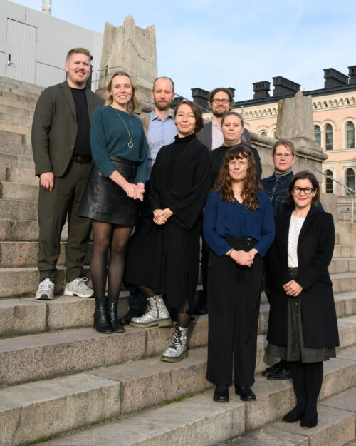 Kuvassa seitsemän henkilöä seisoo portailla.