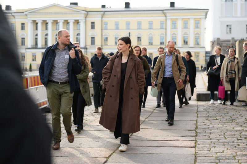 Kuvassa joukko ihmisiä kävelee Helsingin Senaatintorilla.